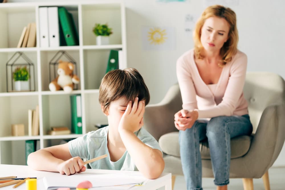 Chłopiec z dysleksją zniechęcony podczas odrabiania lekcji.