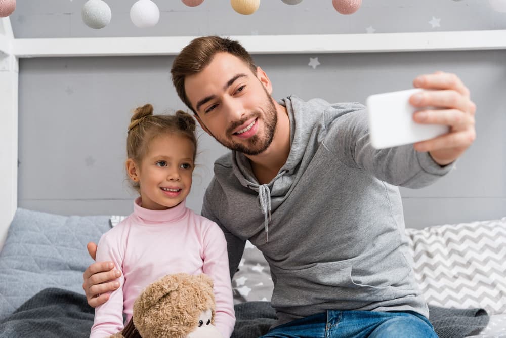 tata robiący sobie zdjęcie z córką