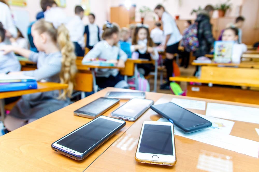 telefony leżące na biurku naczyciela w klasie 