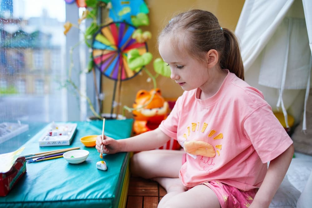 Dziewczynka, która maluje kamyczki. Dziewczynka, która maluje kamyczki.