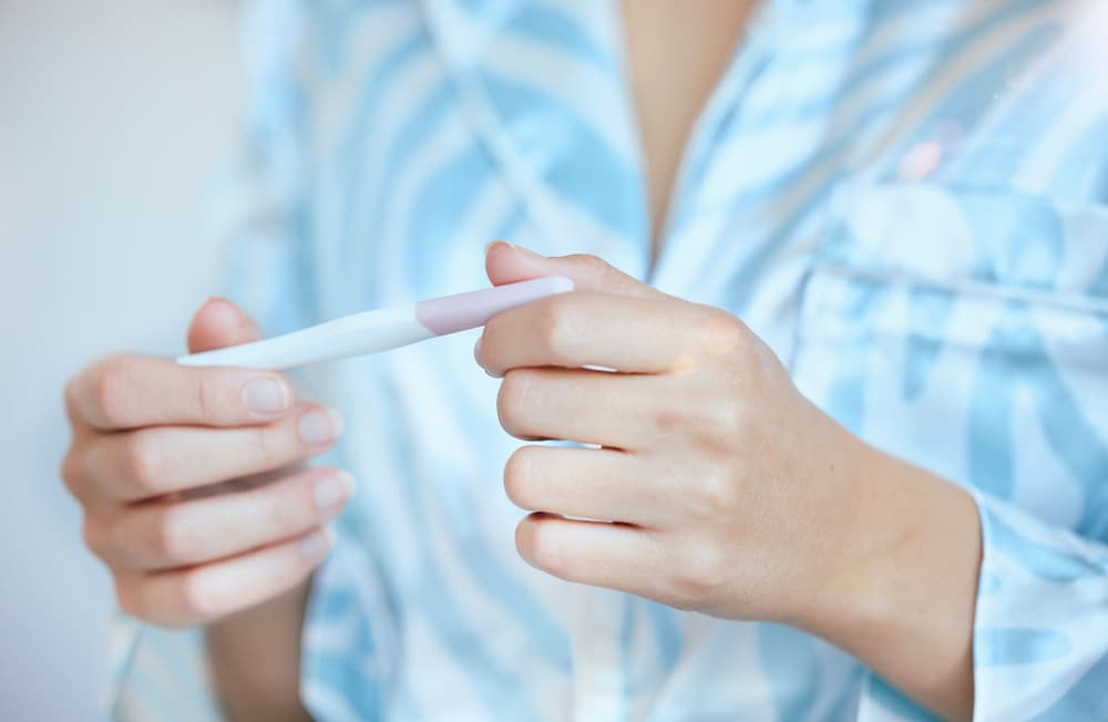 kobieta trzymająca w dłoni test na płodność kobieta trzymająca w dłoni test na płodność