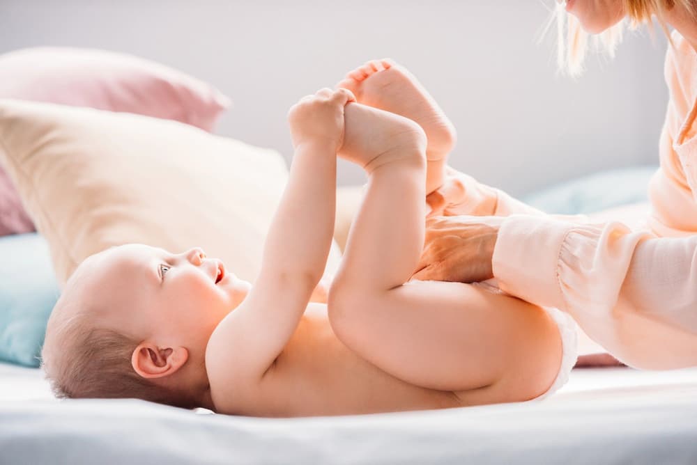 mama zmieniająca dziecku pieluszkę mama zmieniająca dziecku pieluszkę