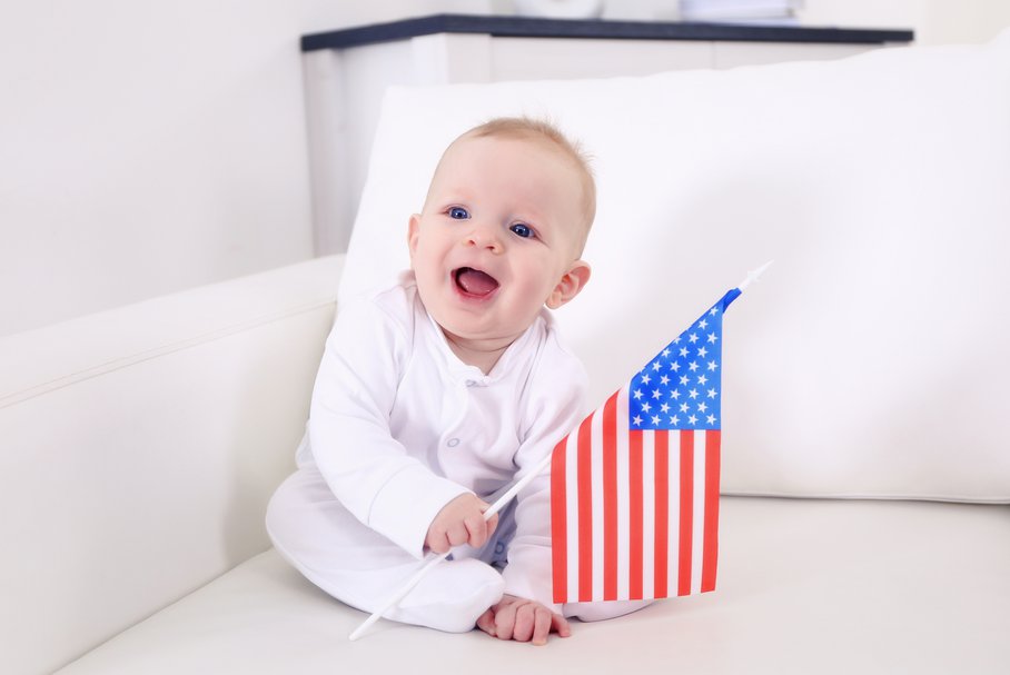 Uśmiechnięty niemowlak trzymający flagę Stanów Zjednoczonych.