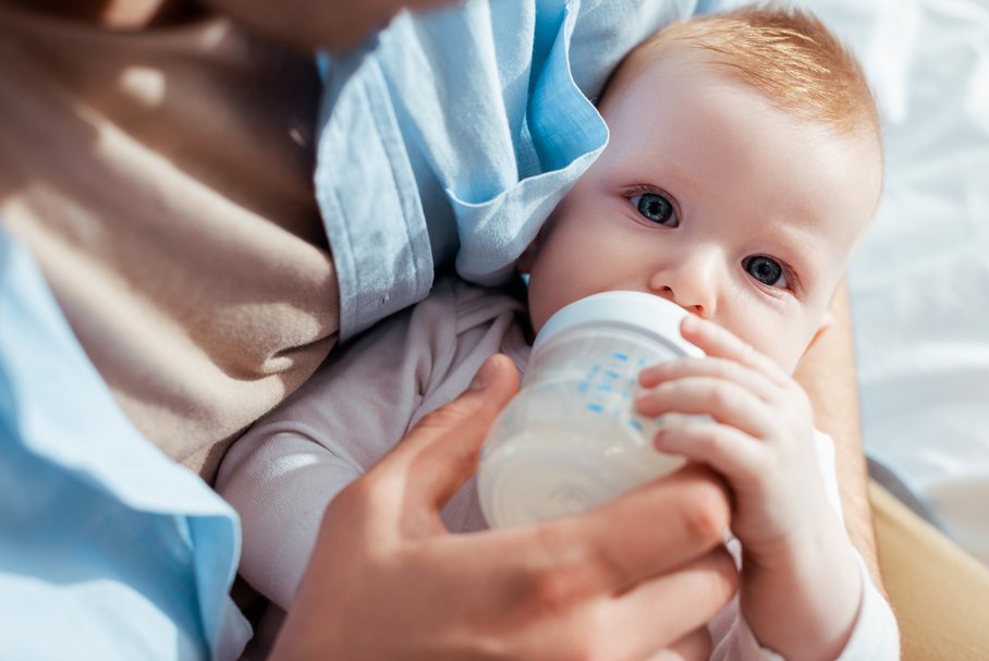 Małe dziecko pijące mleko z butelki.