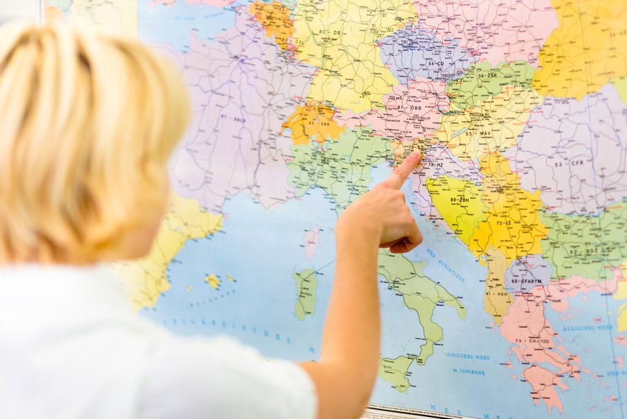 Nauczycielka wskazująca palcem na mapę Europy.