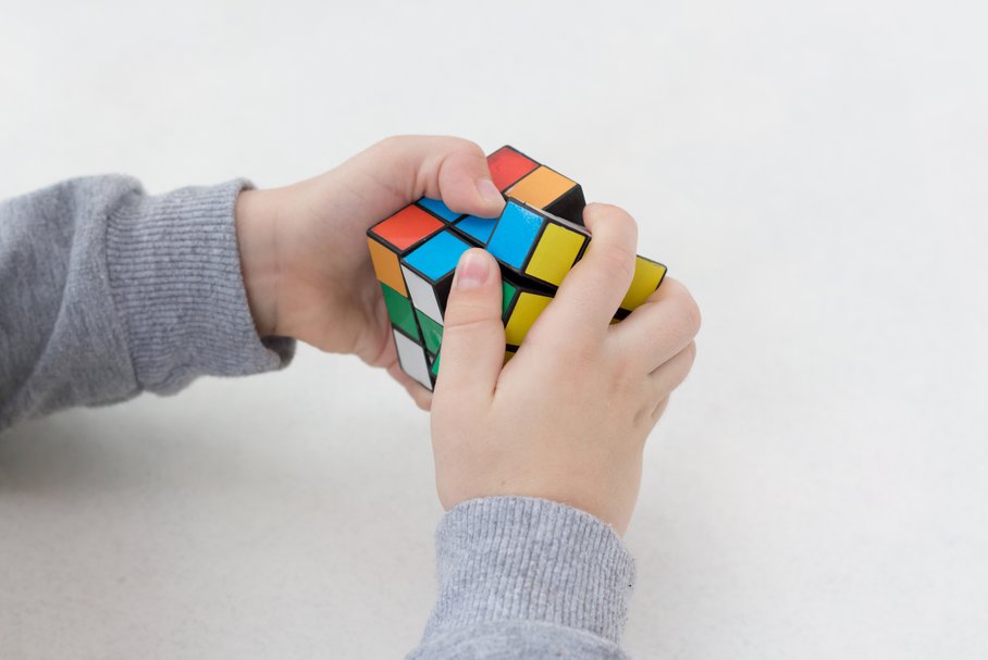 Dziecko układające kostkę Rubika.