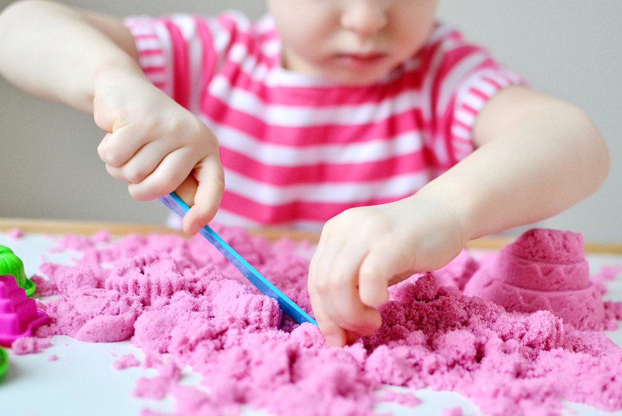 Dziecko bawiące się piaskiem kinetycznym.