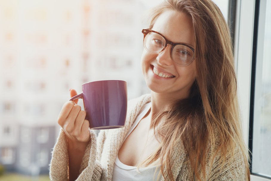 Uśmiechnięta kobieta pijąca kawę zbożową.